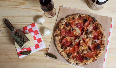 Fresh Pizza on Wooden Table at Restaurant With Bottle of Chianti Wine in Background