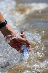 hand picking up glass bottle with message from sea