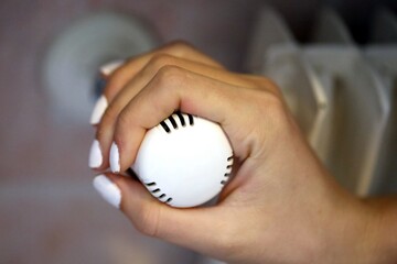 Hand regulating the Thermostatic Valve for setting the temperature of the radiators for energy saving