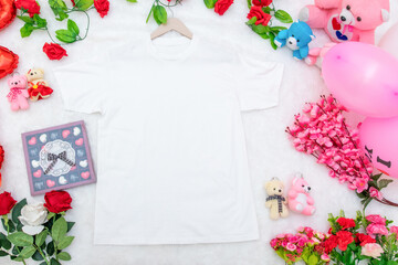 White blank shirt on the top of a fluffy white carpet surrounded by valentine themed decorations