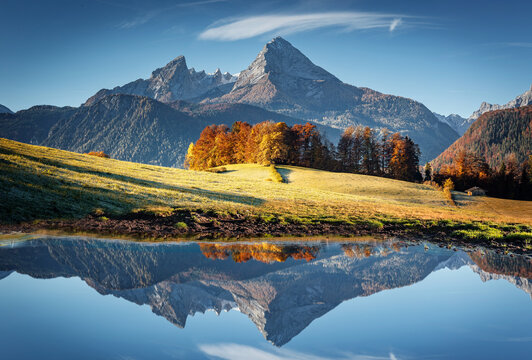 Impressive mountain scenery in the Bavarian Alps. Colorful autumn landscape in the mountains. Watzmann rocky mount  reflections in calm alpine lake under sunlight. creative image. Berchtesgaden land