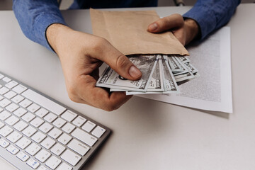 Hands holding an envelope with dollars. Bribery and corruption concept