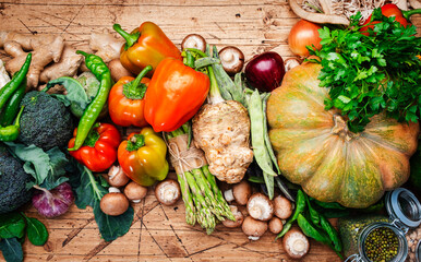 Food background with vegan cooking ingredients. Organic vegetables, pumpkin, mushrooms, asparagus, paprika, legumes, chickpeas on old wooden table, copy space