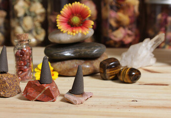 Incense Cones and Chakra Stones With Flowers in Background Shallow DOF