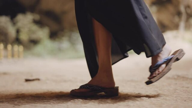 Woman Moving Towards Gold Bollards With Chain