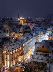 View of Prague roofs from the astronomical clock tower on the Old town Square at night in winter. Snow. Prague. Christmas.
