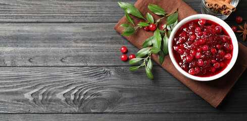 Flat lay composition with cranberry sauce on grey wooden table, space for text. Banner design
