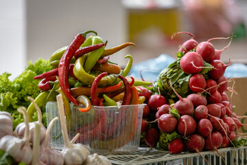 Hot peppers and radishes are for sale on the market