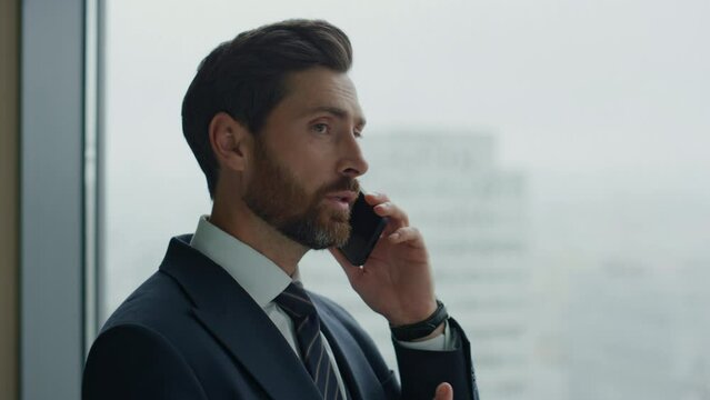Businessman solving business cases using smartphone standing at window close up