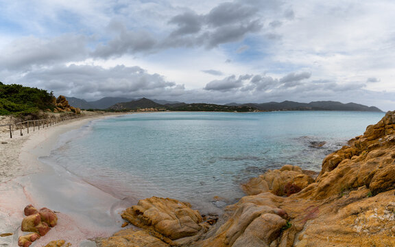 landscape view Porto Giunco Beach near Villasimius in Sardinia with red granite boulders in the foreground