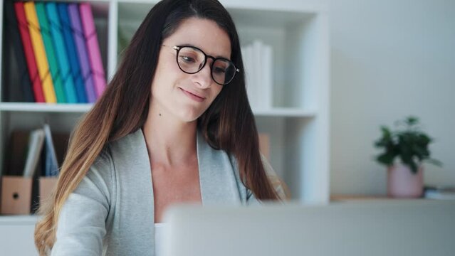 Video of concentrated business woman working with laptop at the office.
