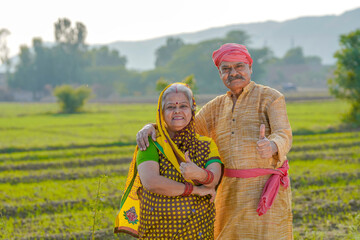senior indian farmer couple showing thumps up at agriculture field - obrazy, fototapety, plakaty