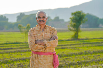 Indian farmer giving expression at agriculture field.