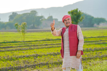Indian farmer showing thumps up at agriculture field. - obrazy, fototapety, plakaty
