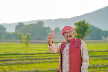 Indian farmer showing thumps up at agriculture field.