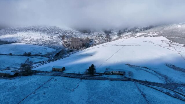 Snowy landscape of cabins and meadows in Puerto de los Tornos, between Cantabria and Burgos. Aerial view from a drone. Castile and Leon, Spain, Europe