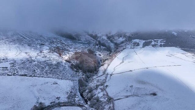 Snowy landscape of cabins and meadows in Puerto de los Tornos, between Cantabria and Burgos. Aerial view from a drone. Castile and Leon, Spain, Europe