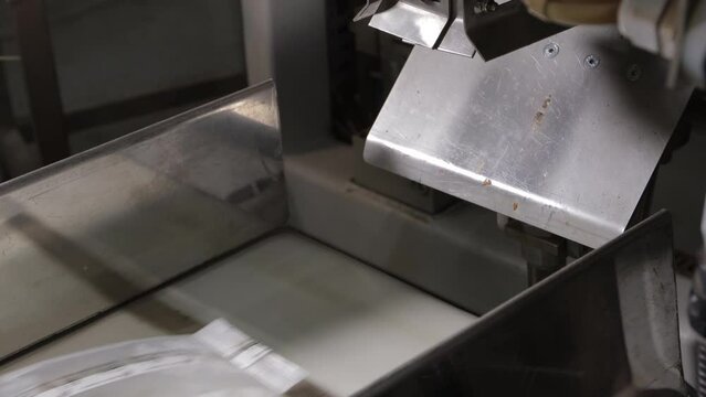 Automatic packaging of tea in transparent bags on the conveyor line of the tea factory.