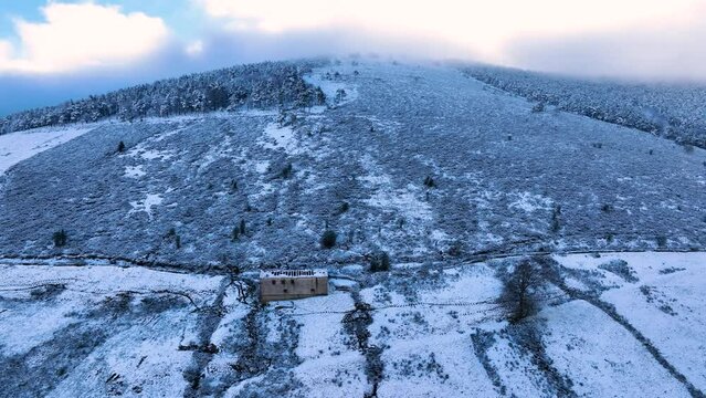 Snowy landscape of cabins and meadows in Puerto de los Tornos, between Cantabria and Burgos. Aerial view from a drone. Castile and Leon, Spain, Europe