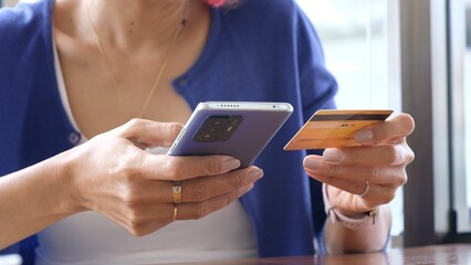close up woman's hand making online payment with credit card via smartphone
