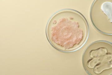 Many Petri dishes and cosmetic products on beige background, flat lay. Space for text