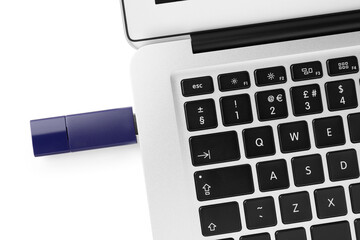Usb flash drive attached into laptop on white background, top view