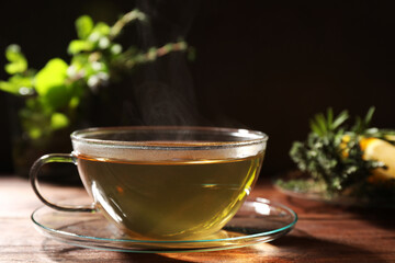Cup of aromatic herbal tea on wooden table