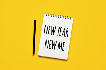 New year new me text in open notepad on yellow background. Setting goals and new years resolution....
