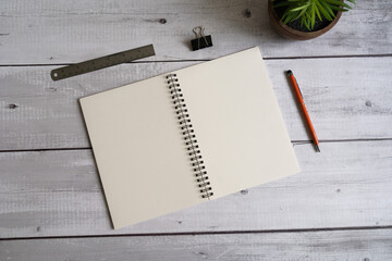 Notebook, A5, A6, metal ring bind, with white cream paper, with pens, metal ruler and plant on a white wood background. Stationary mockup template. 