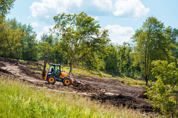 tractor works on landscaping, tree branches and debris - obrazy, fototapety, plakaty