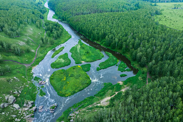 aerial view of the river running through the forest. a swift river with stone banks