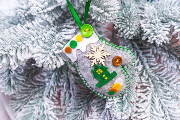 Creative diy craft hobby. Making handmade craft christmas ornaments and balls with felt spruce tree. christmas tree with colorful balls and gift boxes over white brick wall with blue and white balls