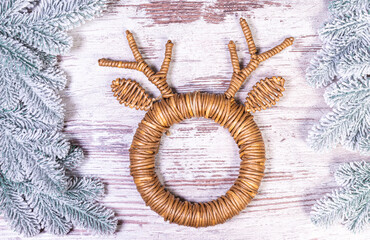 Mock up black poster frame with christmas decoration in home interior, scandinavian style. Green fir branches in a vase, deer and ball on a white table