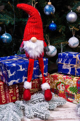 Christmas Elves decorations. Four dwarves with Christmas holiday present is sitting on a wooden shelf. Christmas and New Year concept,