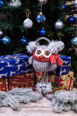 Soft plush toy owl with headphones and knitted scarf. Winter children's gift . Funny knitted red and white toy owl in a red hat and with big eyes
