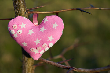 An image of a soft toy in the shape of a heart. Handicraft work.