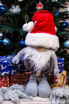 Christmas Elves decorations. Four dwarves with Christmas holiday present is sitting on a wooden shelf. Christmas and New Year concept,