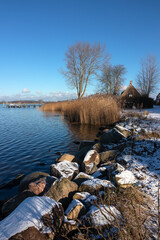 Portrait of a thatched cottage in beautiful winter landscape at the Schlei fjord in the historic...