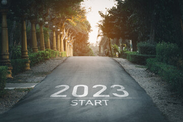 Happy new year 2023,2023 symbolizes the start of the new year. The letter start new year 2023 on the road in the nature garden park have tree environment ecology or greenery wallpaper concept. - obrazy, fototapety, plakaty