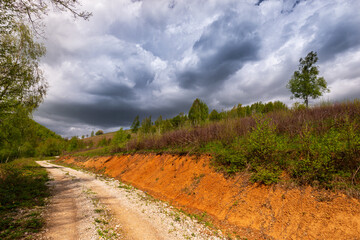 Beautiful country road in spring in remote rural area in Eastern Europe and storm April sky