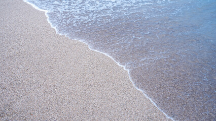 Background of a beach with white sand and lovely tiny waves throughout the day
