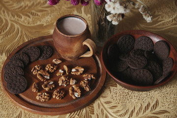 Still life of delicious sweet cookies with milk, flowers and nuts.