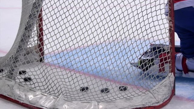 Ice Hockey cinematic slow motion footage of goals net hit by puck. Player Hitting Puck with stick scores goal missed by Goalie. Stylish Cinematic Close-up, Dramatic Lighting, 1000 fps Slow Motion Shot