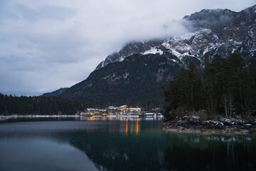 Snowy Eibsee Lake views in the winter with crystal clear water in the forest of European alps
