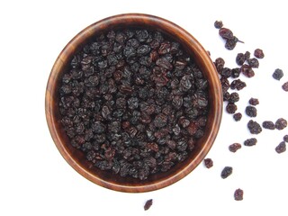 Dried Blackcurrant in a wooden bowl isolated on white background top view 