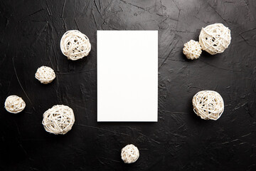 Card mockup, blank wedding invitation with white white balls decor on black table
