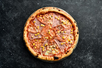 Pizza with bacon, corn and cheese. Takeaway food. Top view. On a black stone background.