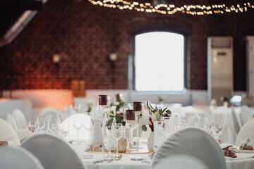 Gedeckter Tisch auf Hochzeitsfeier mit Blumen und Kerzen