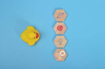 Toy duck and wooden blocks with strategy, success, new idea and innovation symbols.