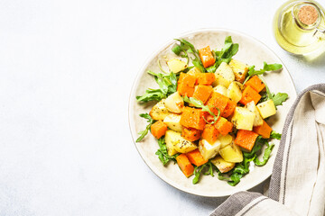 Warm salad with pumpkin, potato and arugula.